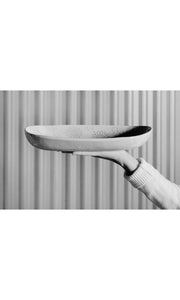 Arm outstretched holding large rice dish salad bowl, handmade by Wonki Ware in South Africa, available at Amara Home.