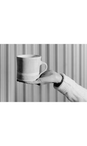 Hand holding black wash Straight Mug, handmade by Wonki Ware in South Africa, available at Amara Home.